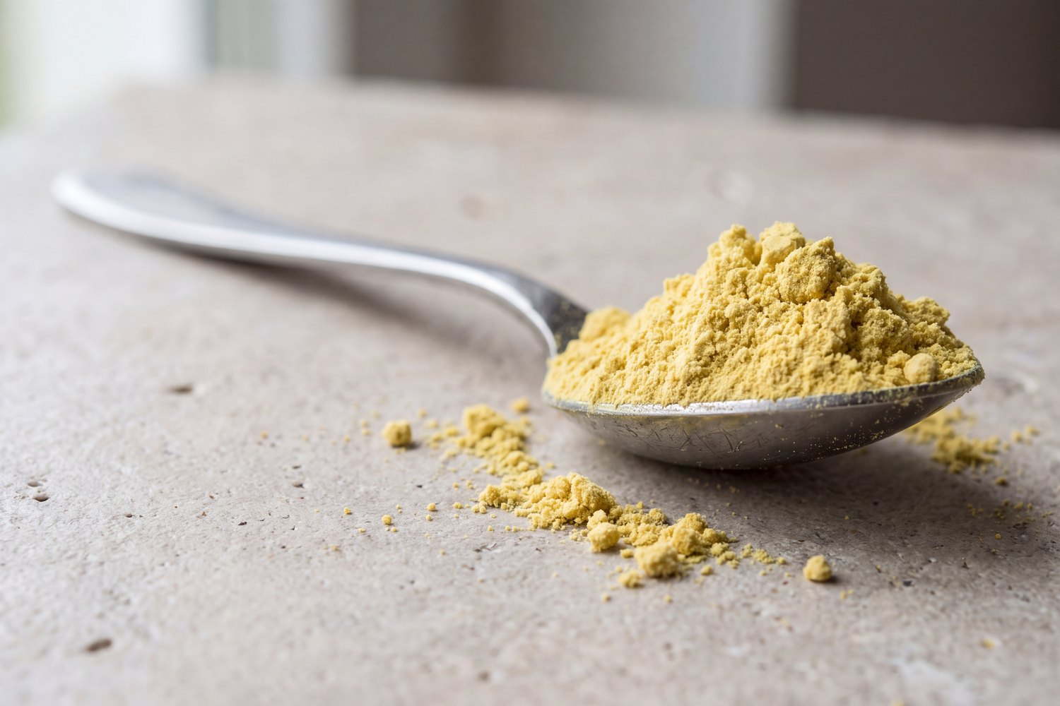 A teaspoon heaped full of canary-yellow powder