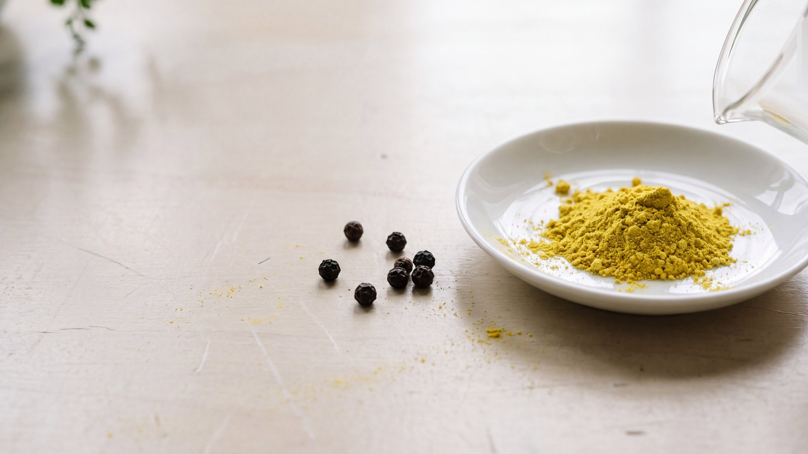 Golden berberine powder, cracked black pepper and barberry on warm stone
