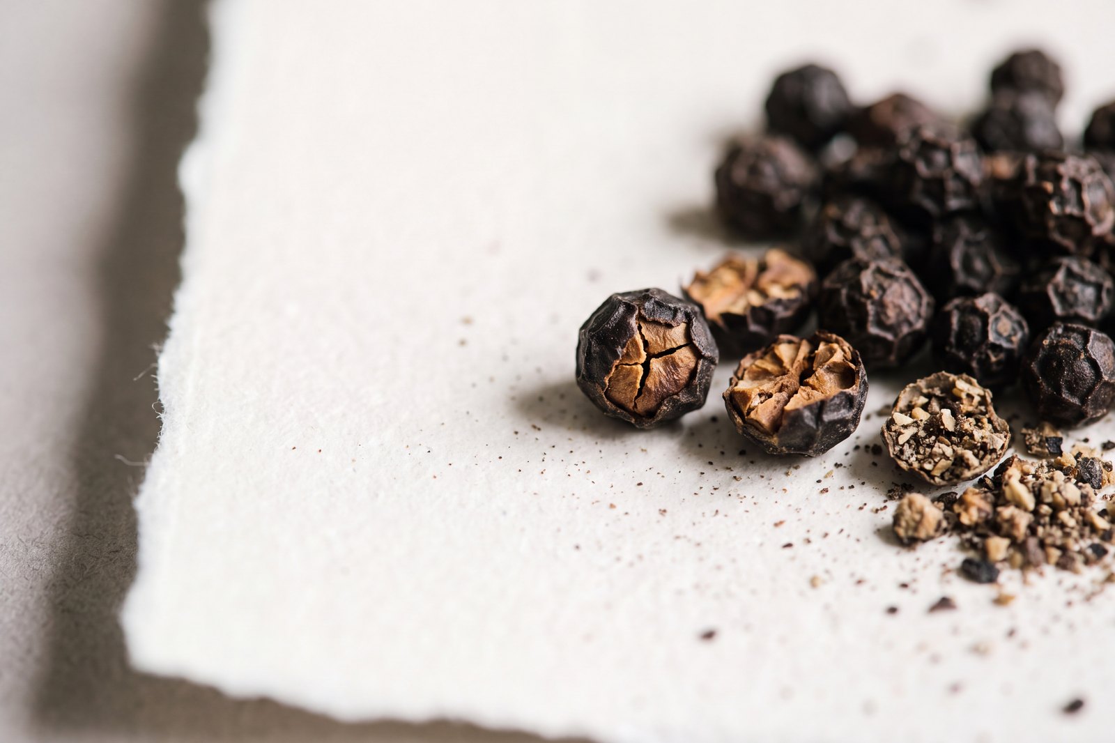 Extreme macro of cracked black peppercorns, the natural source of piperine