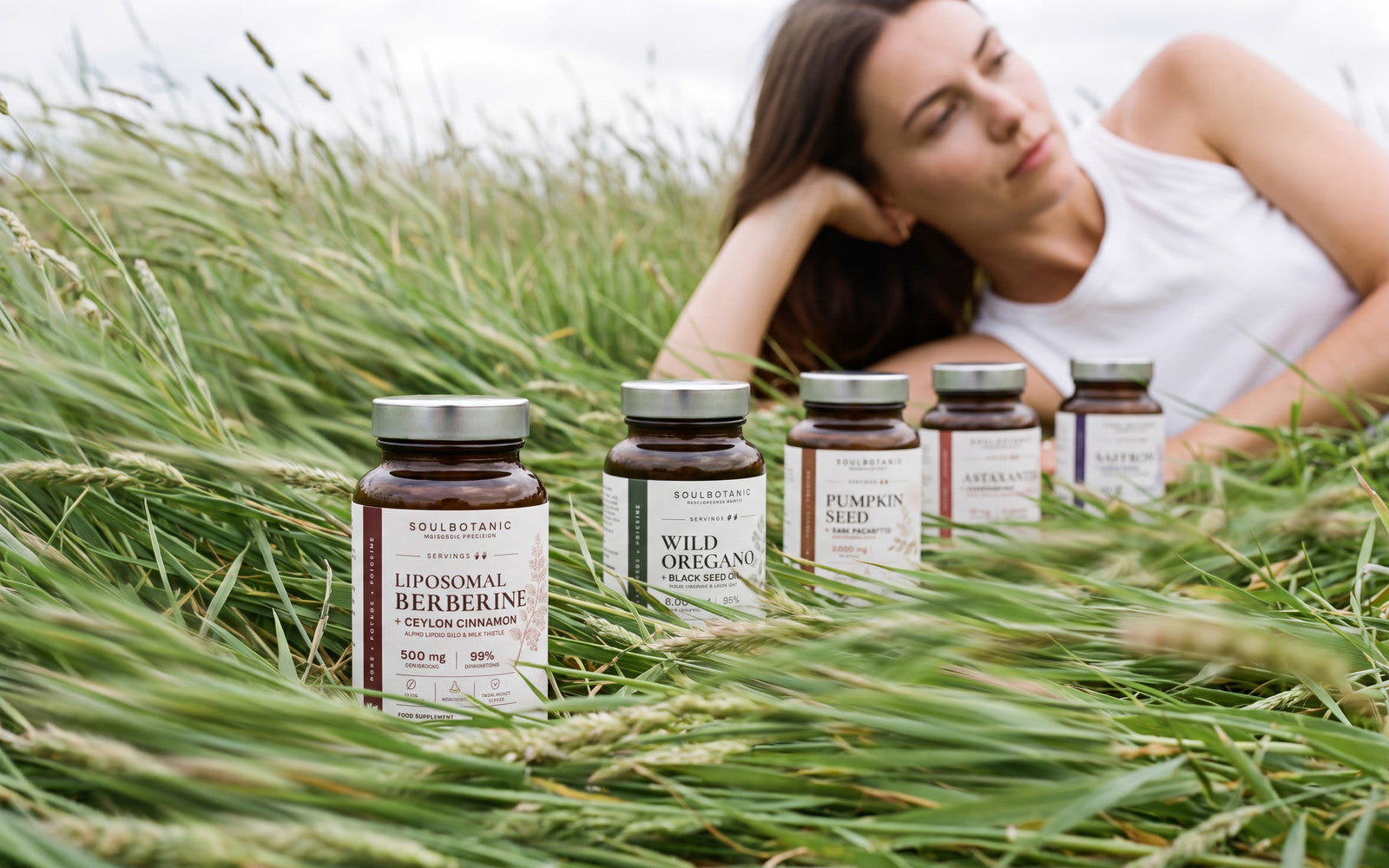 Five formulas standing in a summer meadow, a woman resting in the grass behind them