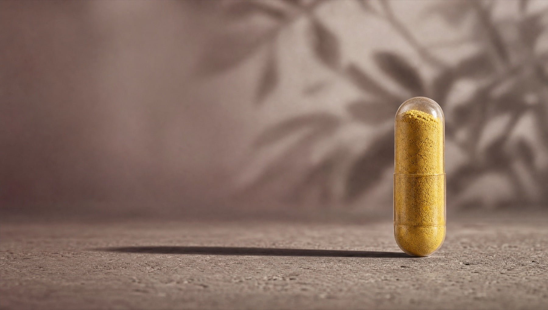 An intact yellow-powder berberine capsule on a quiet stone surface