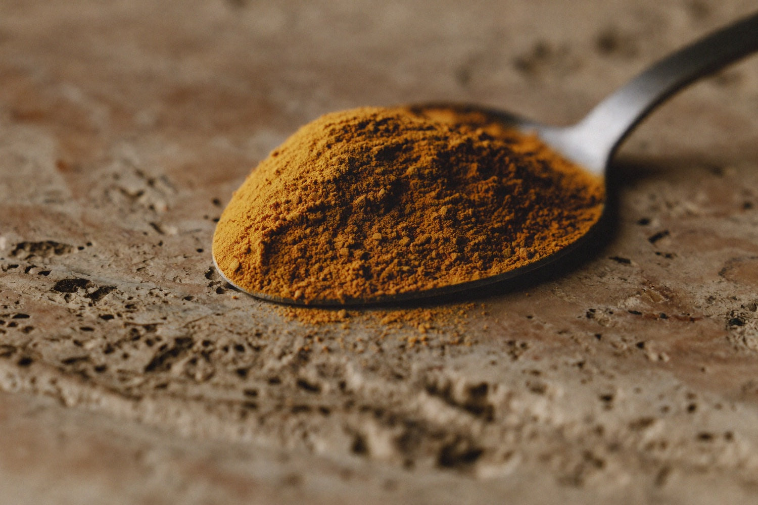 A spoon heaped full of golden powder